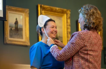 Vrolijk wordt de Scheveningse klederdracht aangetrokken tussen de schilderijen in Muzee